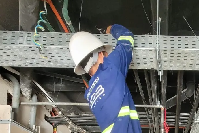 Técnico da G2B uniformizado trabalhando na eletrocalha